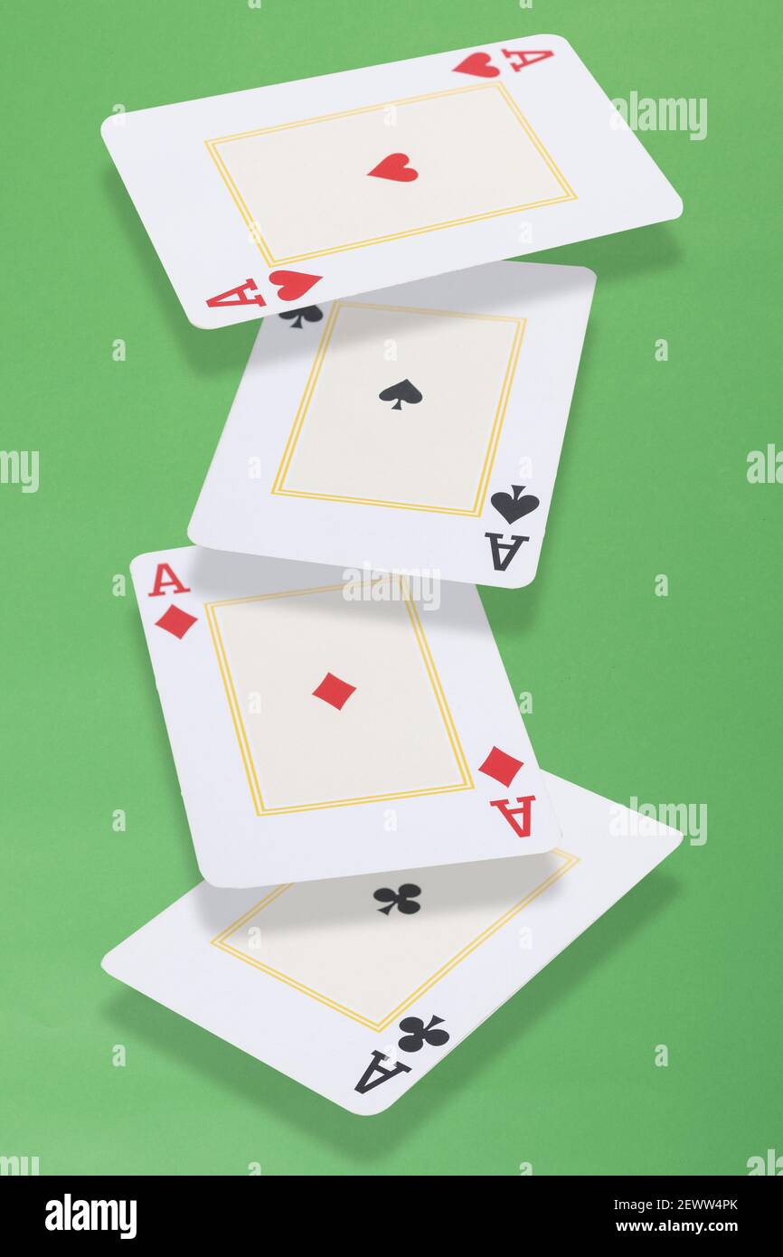 Quattro assi carte galleggianti su sfondo verde. Foto Stock