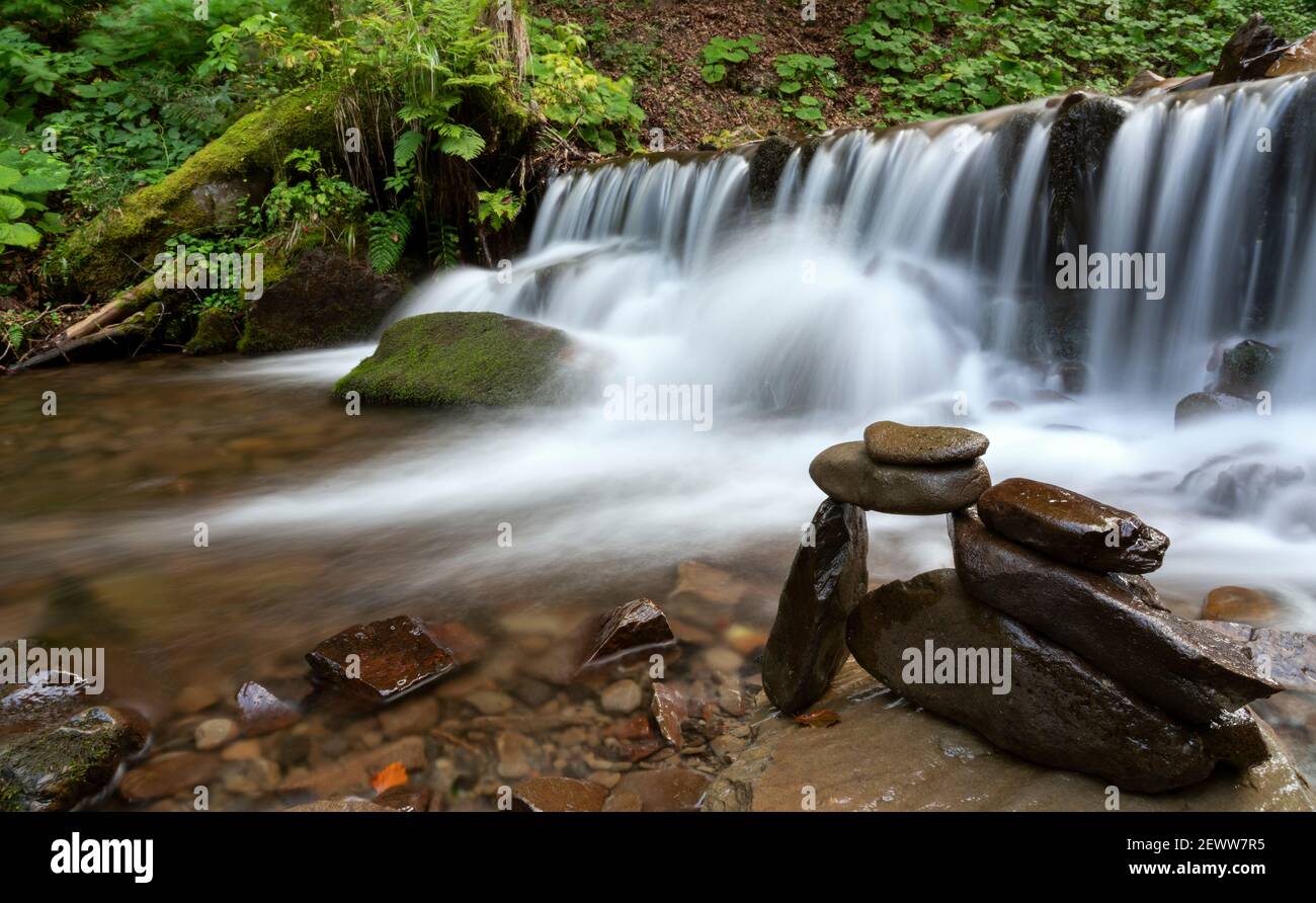 Pietre bilanciate impilate accanto alla cascata sul fiume di montagna Foto Stock Pietre bilanciate impilate accanto alla cascata sul fiume di montagna Foto Stock