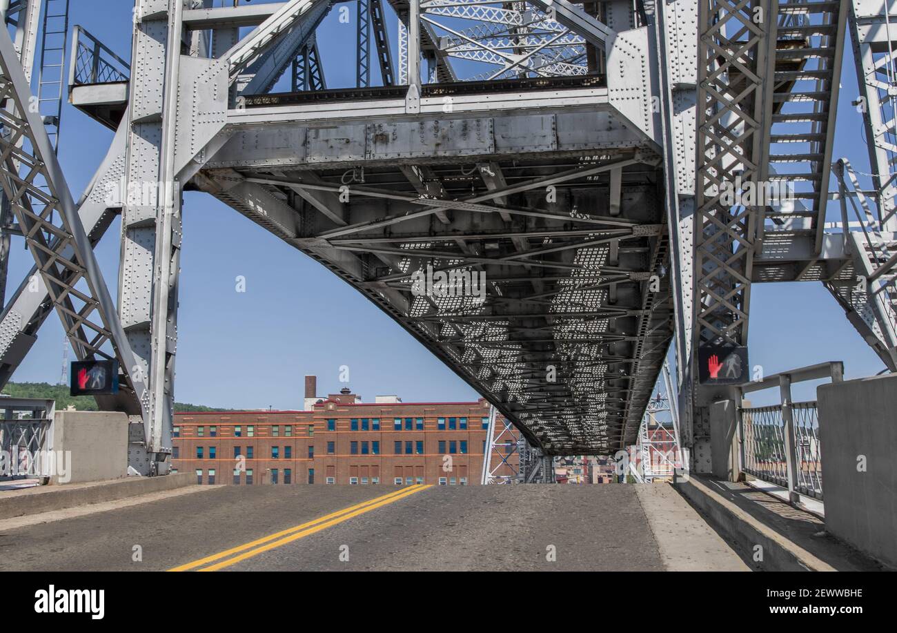 Ponte elevatore in alto: La parte centrale di un grande ponte mostra il suo lato inferiore mentre si erge sopra la carreggiata per consentire il passaggio di barche a Duluth, MN porto. Foto Stock