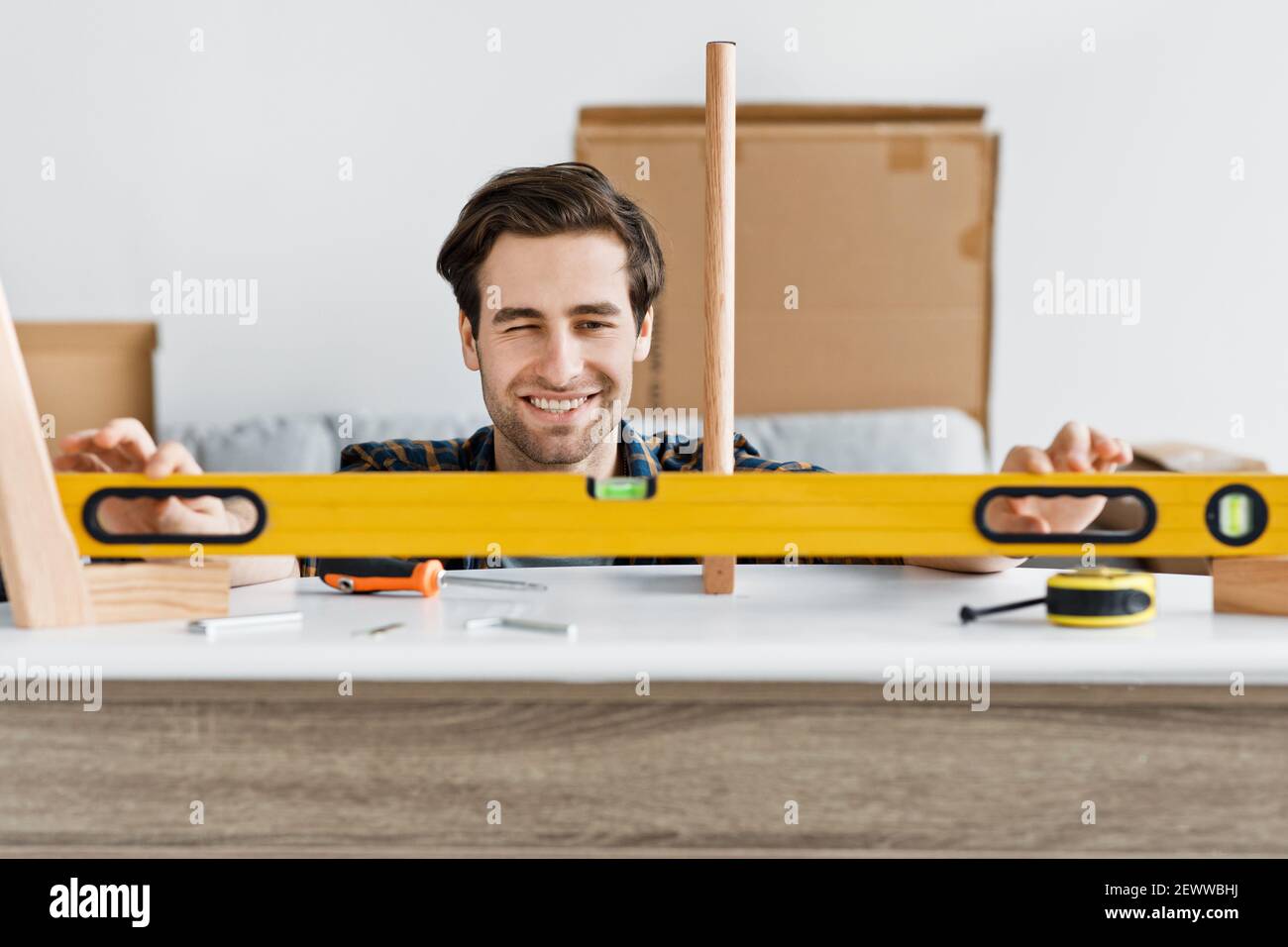 Allegro handyman che lavora a casa, riparando, assemblando e ristrutturando o nuovo hobby Foto Stock