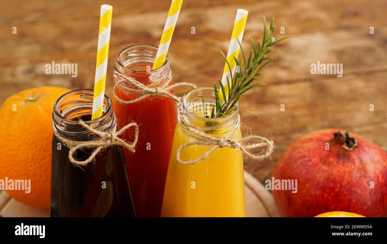 Limonata fatta in casa in piccole bottiglie. Succhi e frutta multicolore Foto Stock