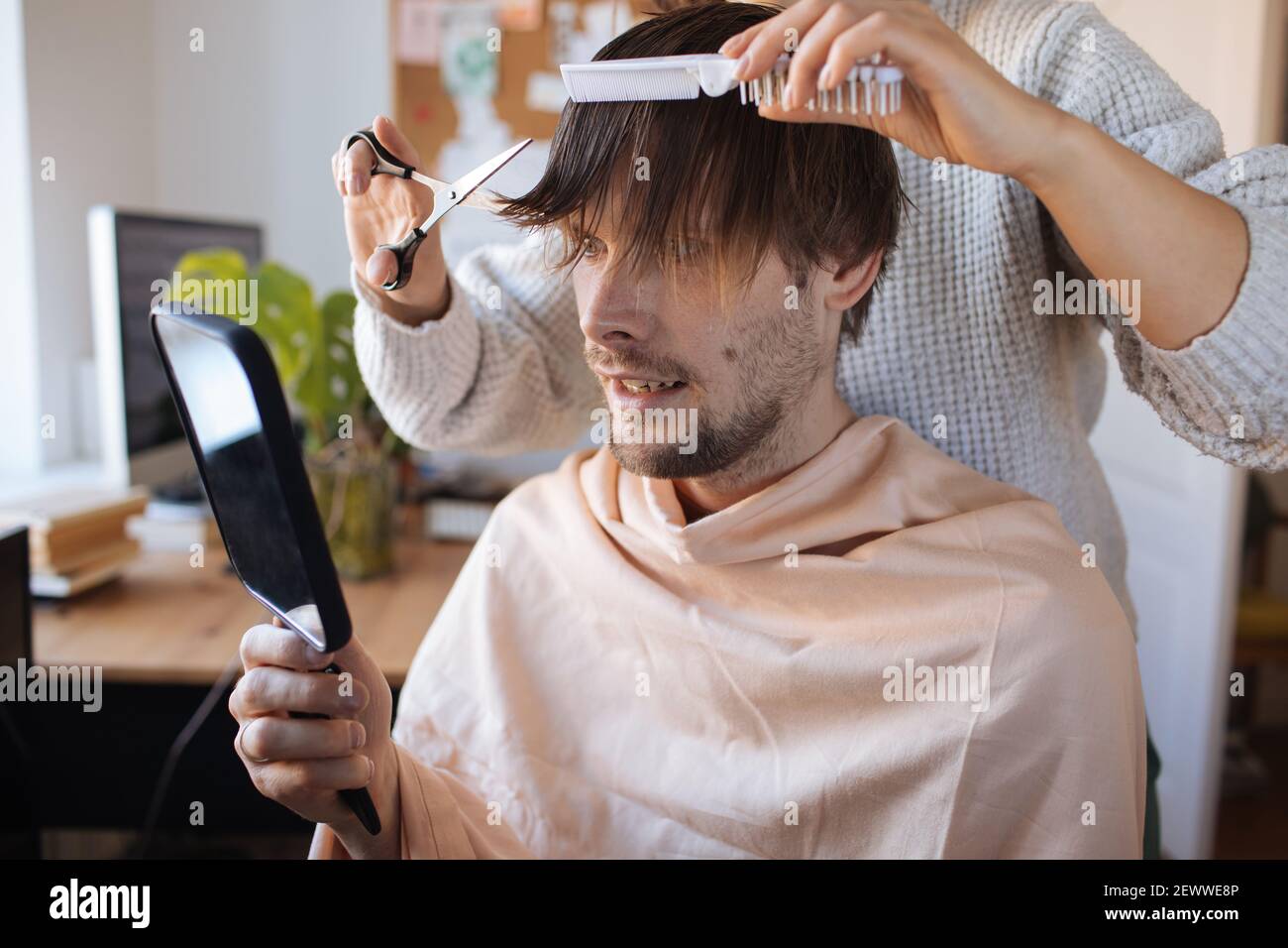 Taglio capelli casa. Uomo che taglia i capelli a casa. Vita in pandemia durante il blocco. Come tagliare i vostri propri capelli quando i parrucchieri sono chiusi. Taglio automatico più semplice Foto Stock