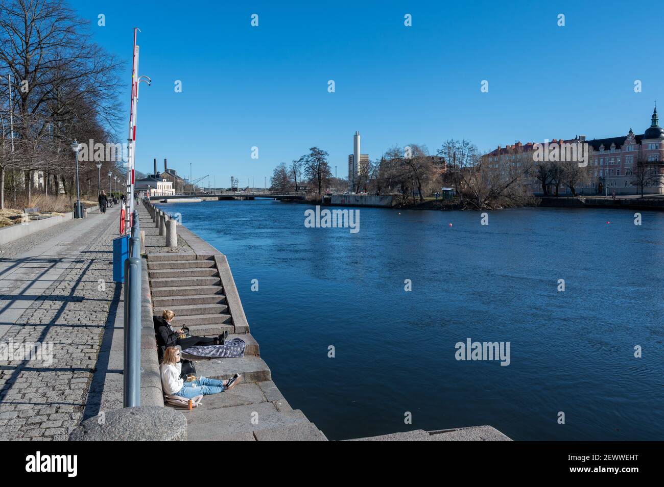 La gente può godersi una giornata primaverile al Norrköping Waterfront Saltängen alla fine di febbraio 2021. Norrkoping è una storica città industriale svedese. Foto Stock