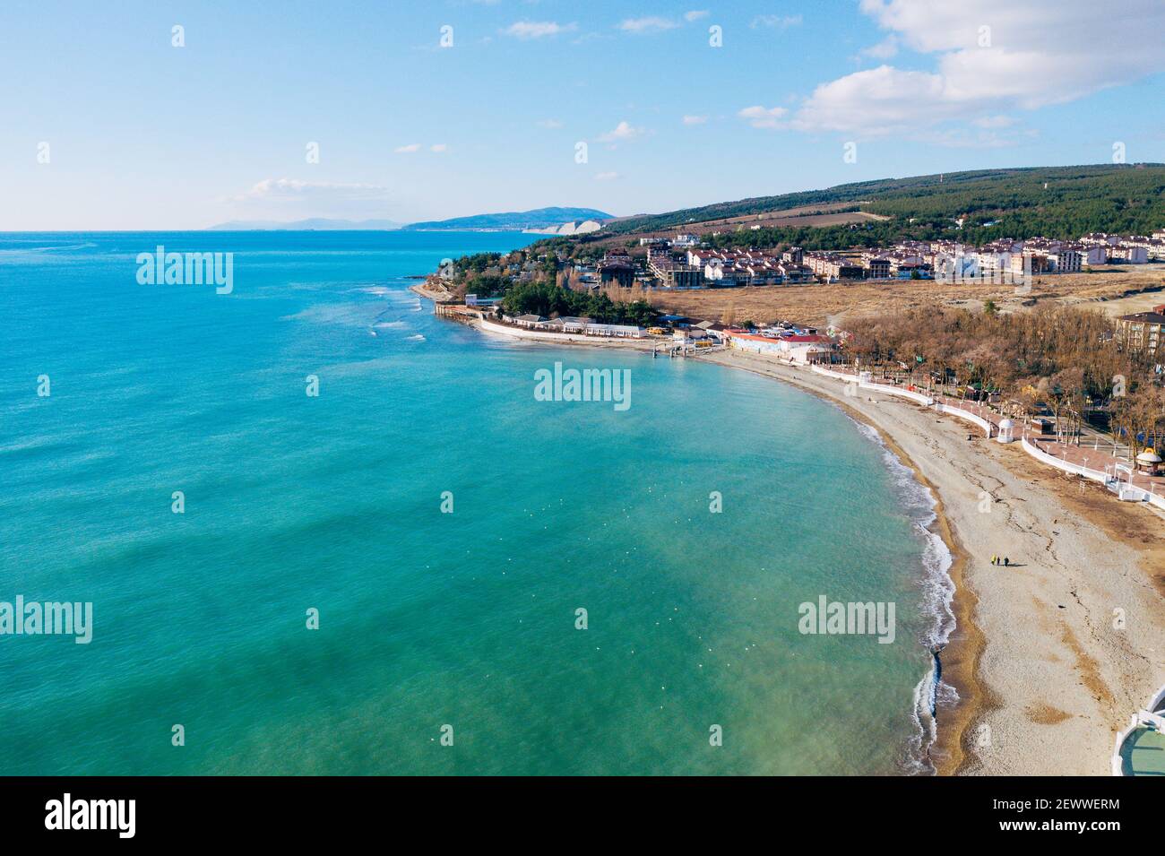 Vista aerea della costa con spiaggia di sabbia e piccoli edifici. Bel mare blu e azzurro dal drone. Foto Stock