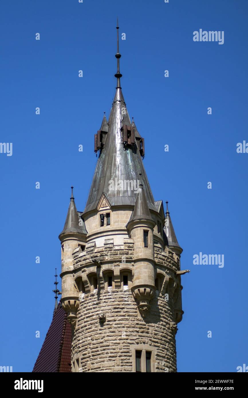 La torre del castello è costruita in pietra e coperta di lamiera. Cielo perfettamente blu come sfondo. Foto Stock