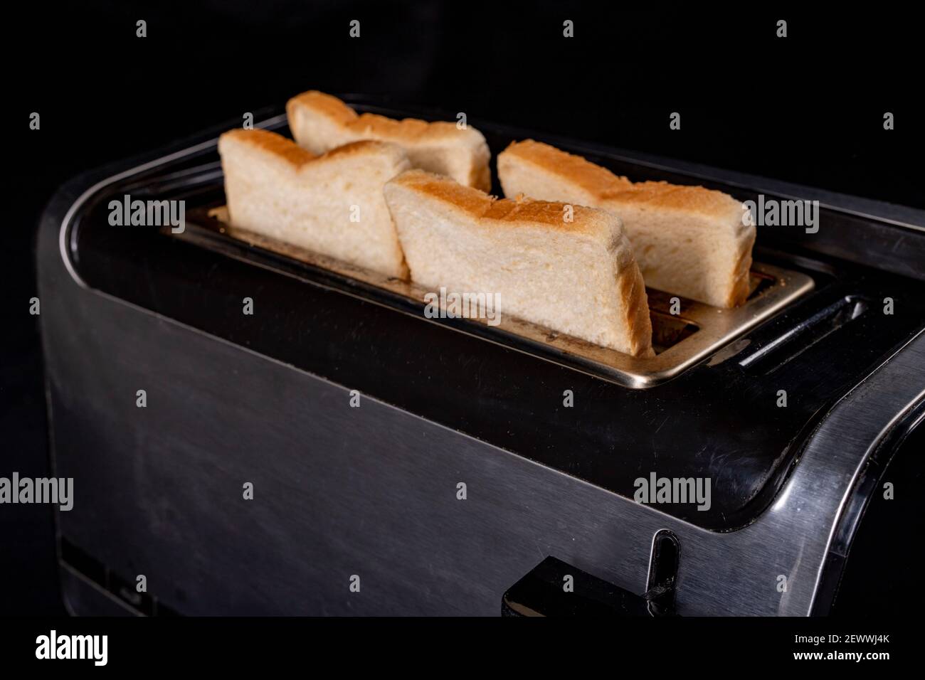 Un moderno tostapane per tostare il pane. Elettrodomestico per la produzione di casserole. Sfondo scuro. Foto Stock