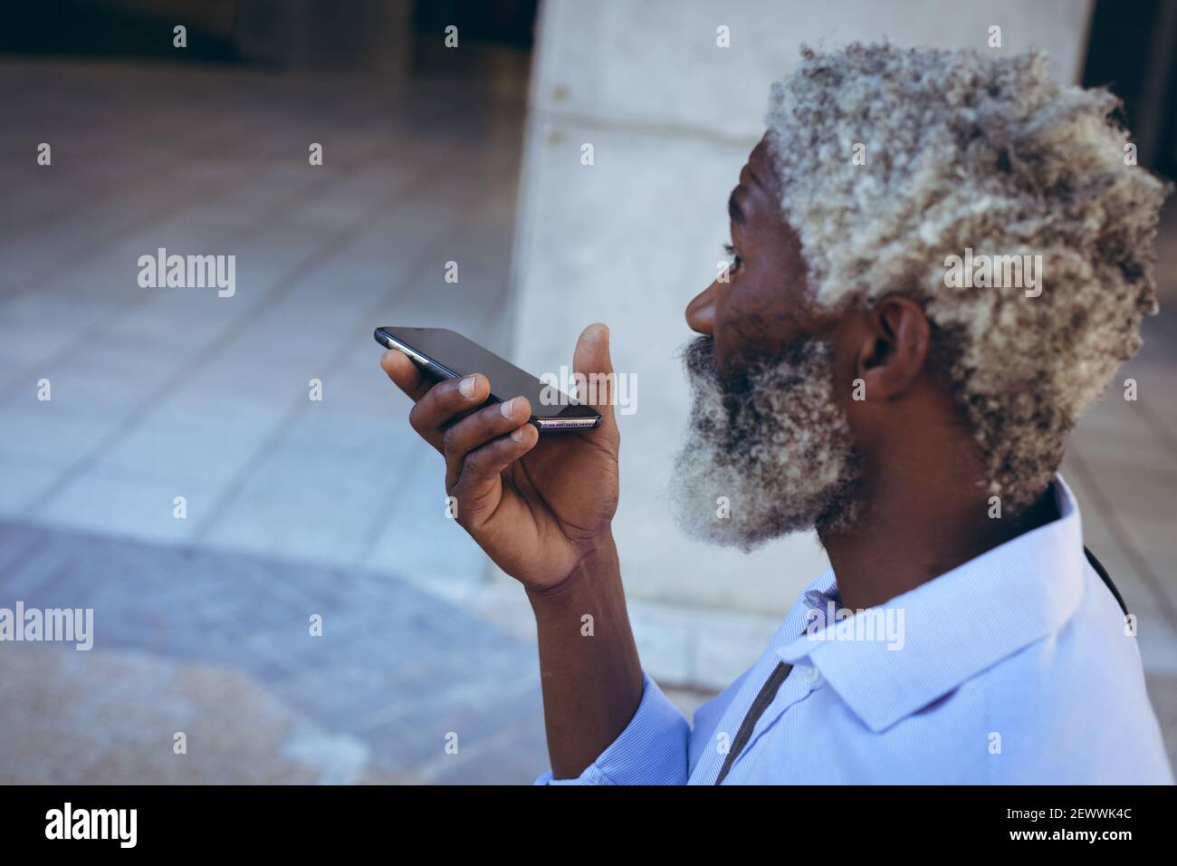 Uomo anziano afro-americano in piedi per strada che parla su smartphone Foto Stock