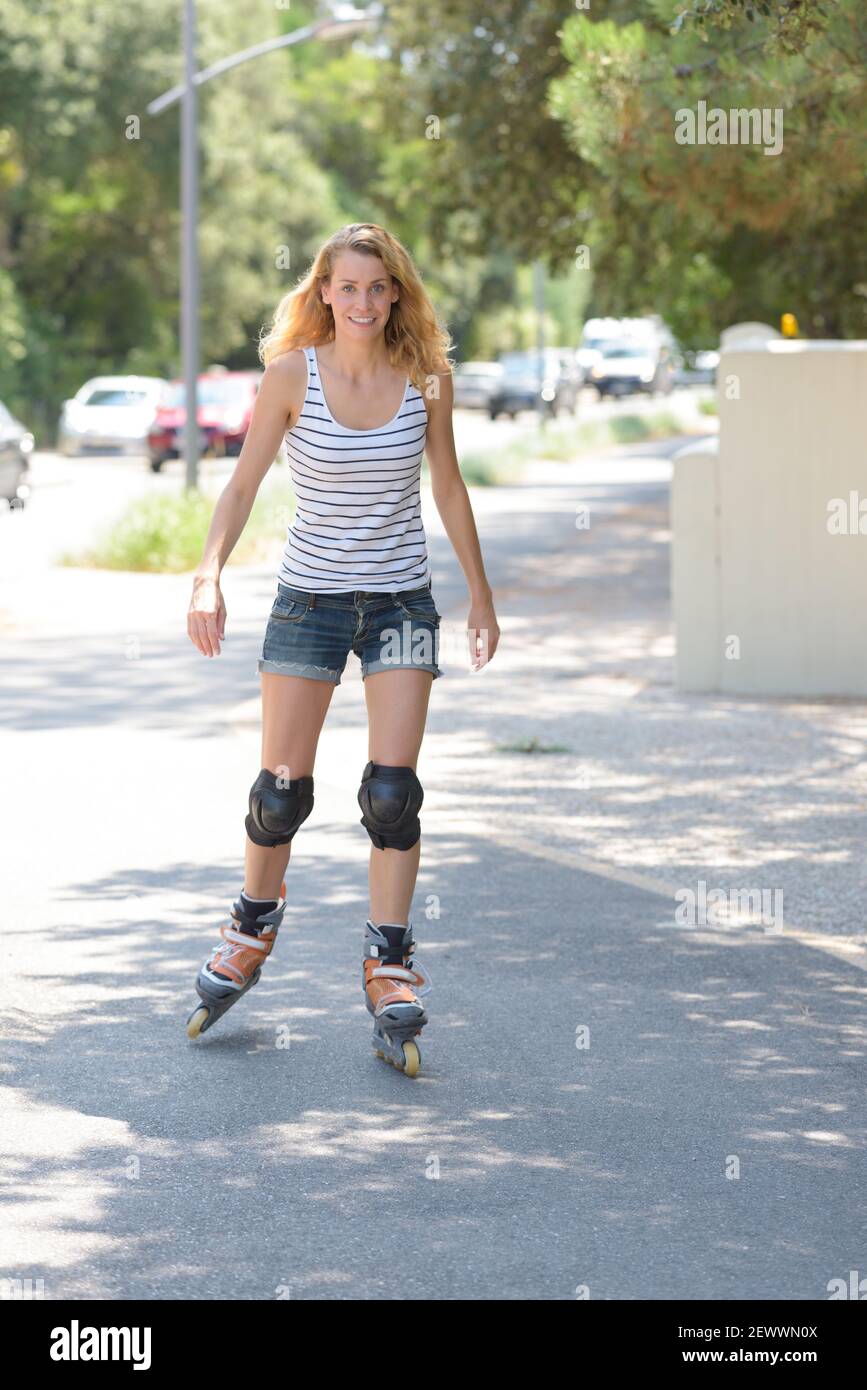 bella giovane donna che fa skate a rulli Foto Stock