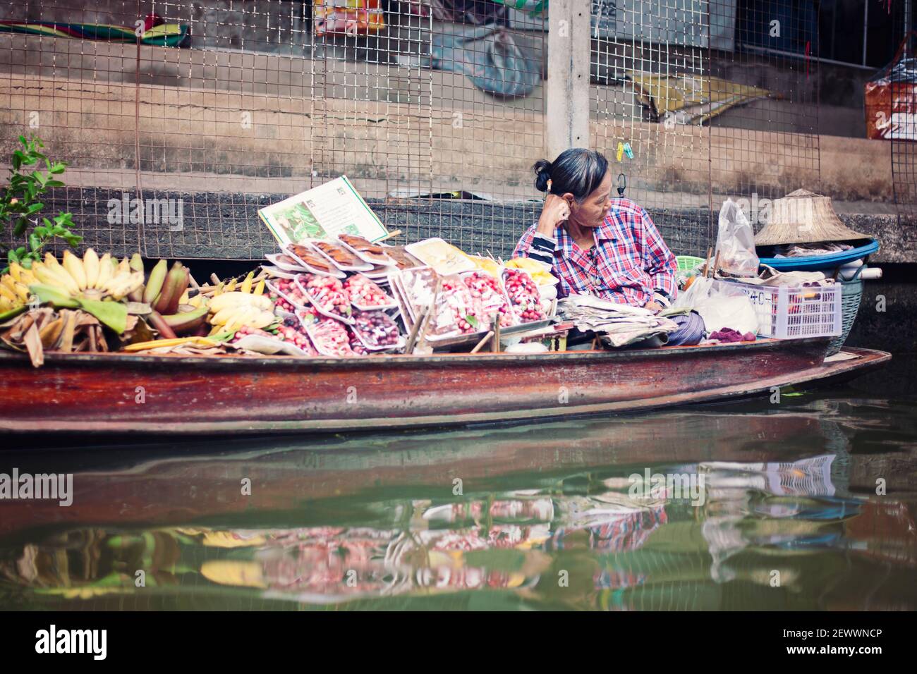 Donna che lavora al mercato galleggiante in Thailandia. Foto Stock