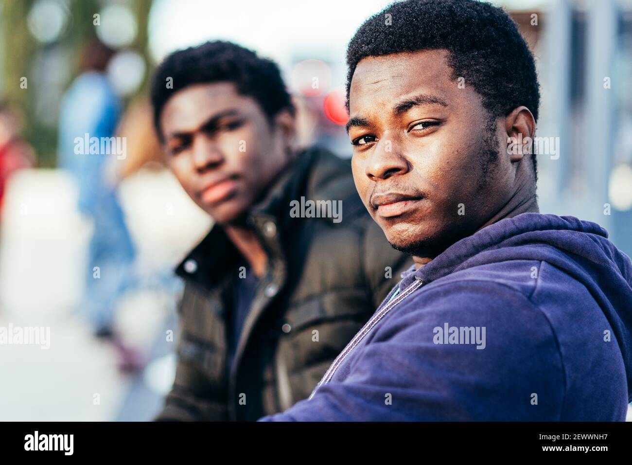 Ritratto di due amici afro-americani seduti in uno spazio urbano. Foto Stock