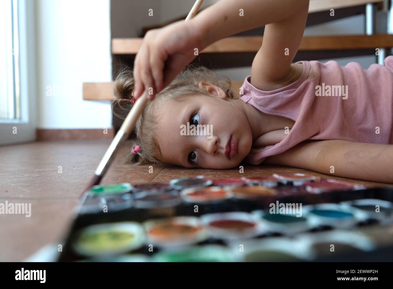 ragazza dipinge un'immagine sul pavimento Foto Stock