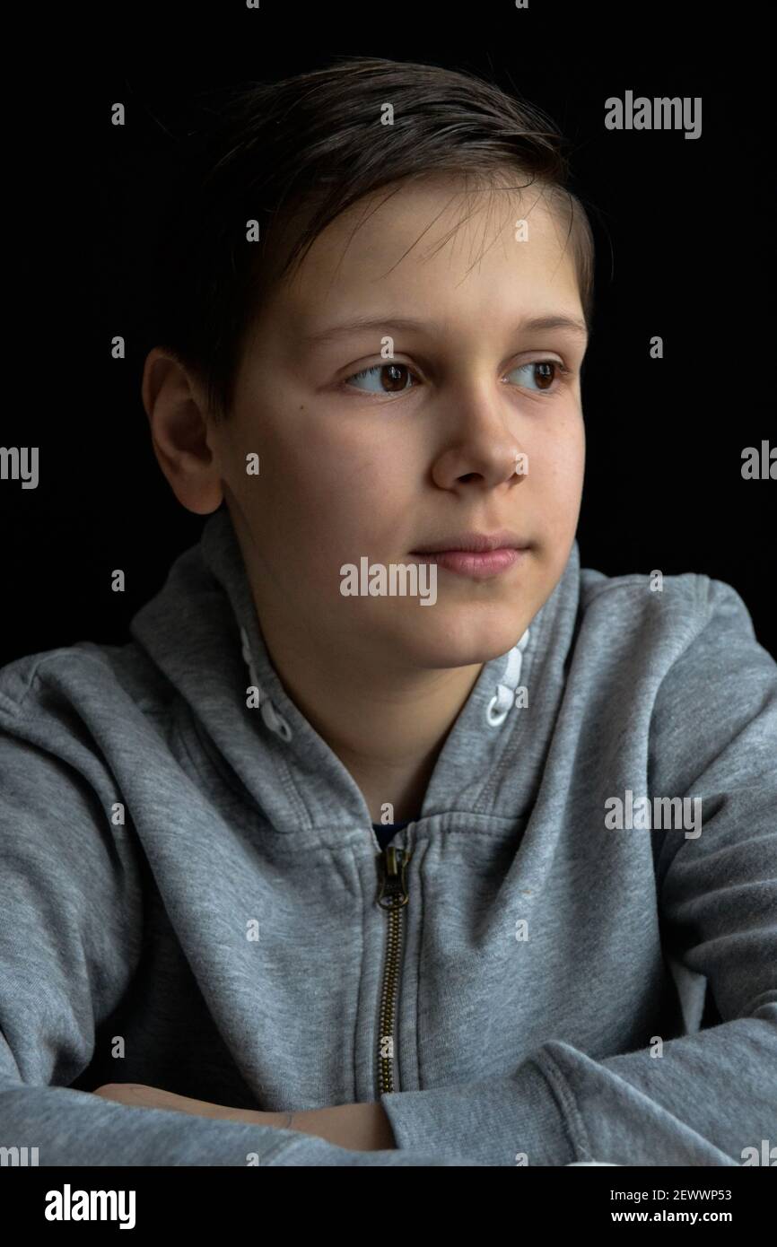 ritratto di ragazzo davanti a sfondo nero Foto Stock