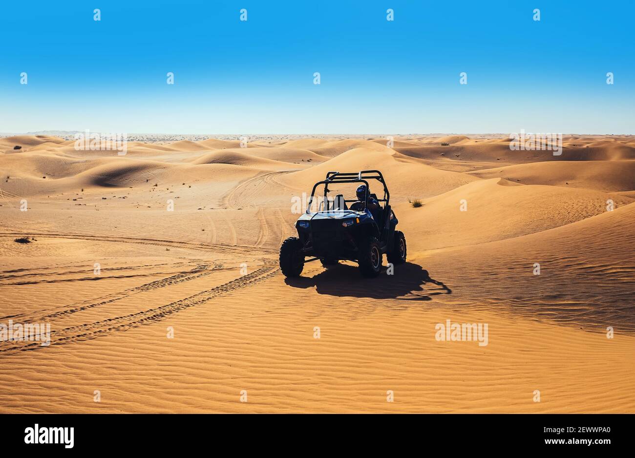Vista panoramica del deserto soleggiato giorno con giro in quad estremo veicolo Foto Stock