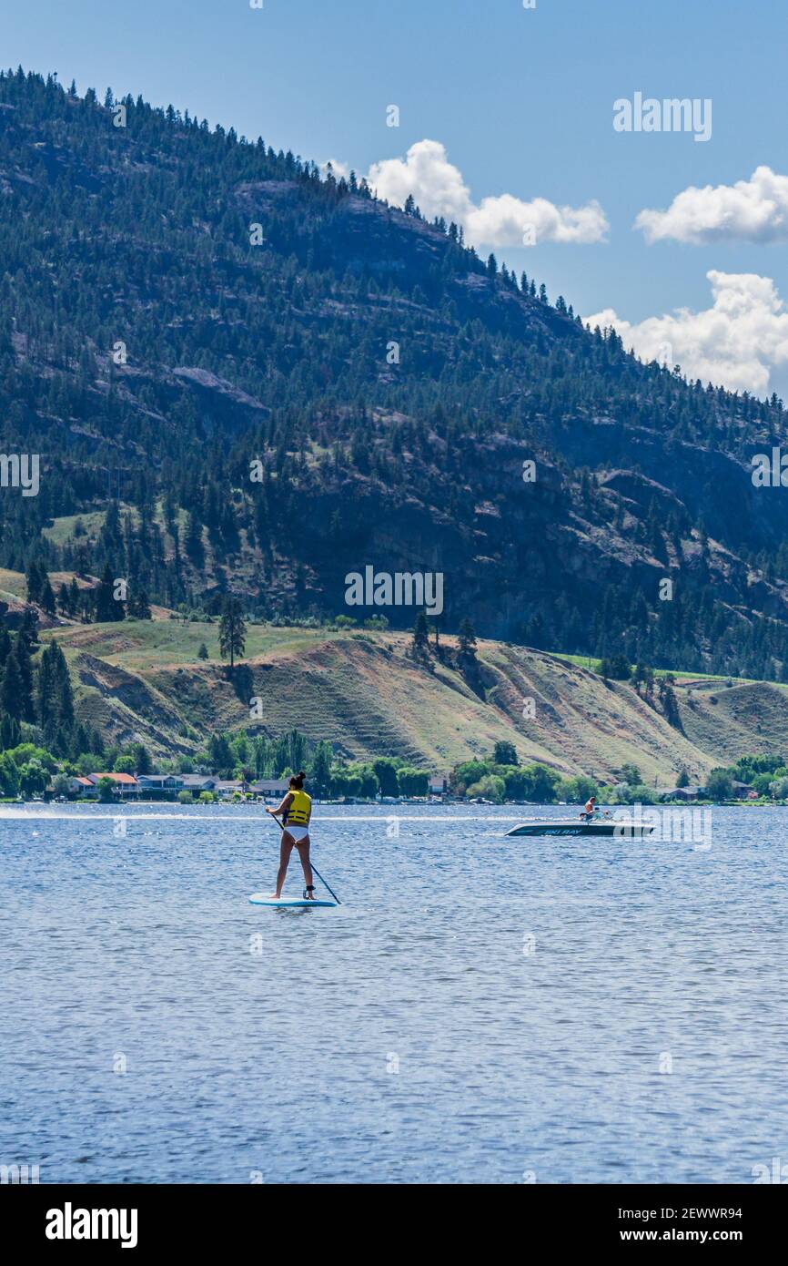 PENTICTON, CANADA - 5 LUGLIO 2020: Tempo di ricreazione paddle boarding sul panoramico e tranquillo lago di montagna Foto Stock