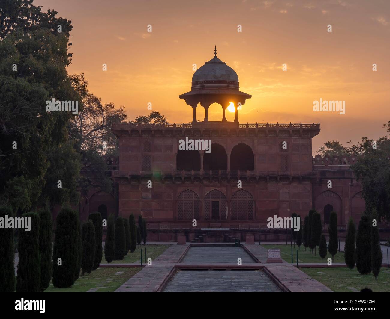 AGRA, INDIA - MARZO, 26, 2019: Il sole sorge dietro una cupola baldacchino sul naubat khana edificio nei giardini del taj mahal Foto Stock