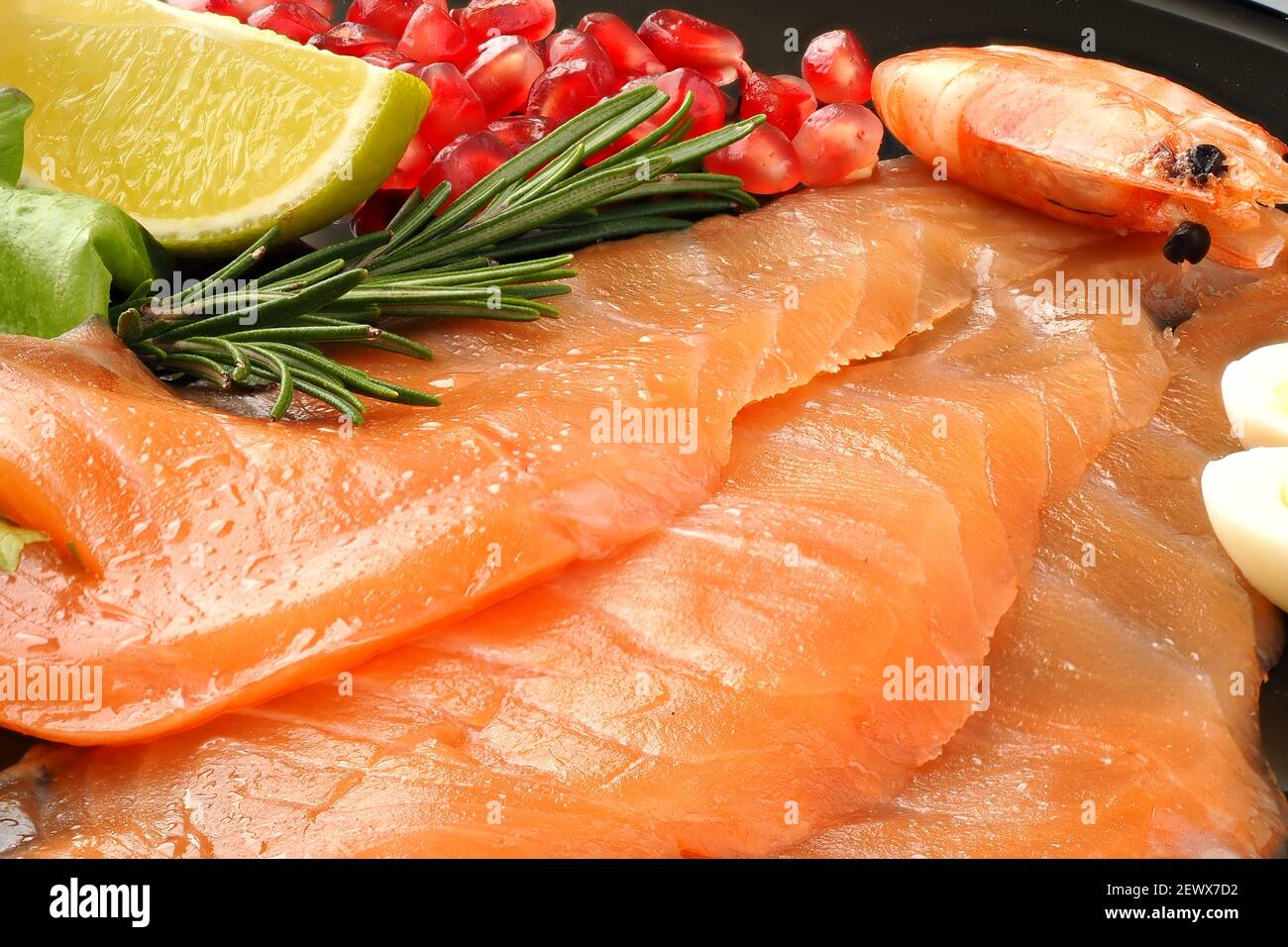 Appetitose fette di salmone affettato con gamberi al limone e melograno, cibo delizioso. Foto Stock