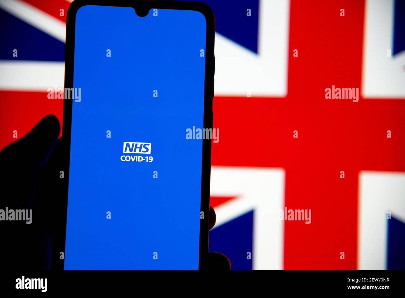 Silhouette di persona che utilizza l'applicazione per dispositivi mobili NHS Covid-19 UK in cellulare samsung Foto Stock