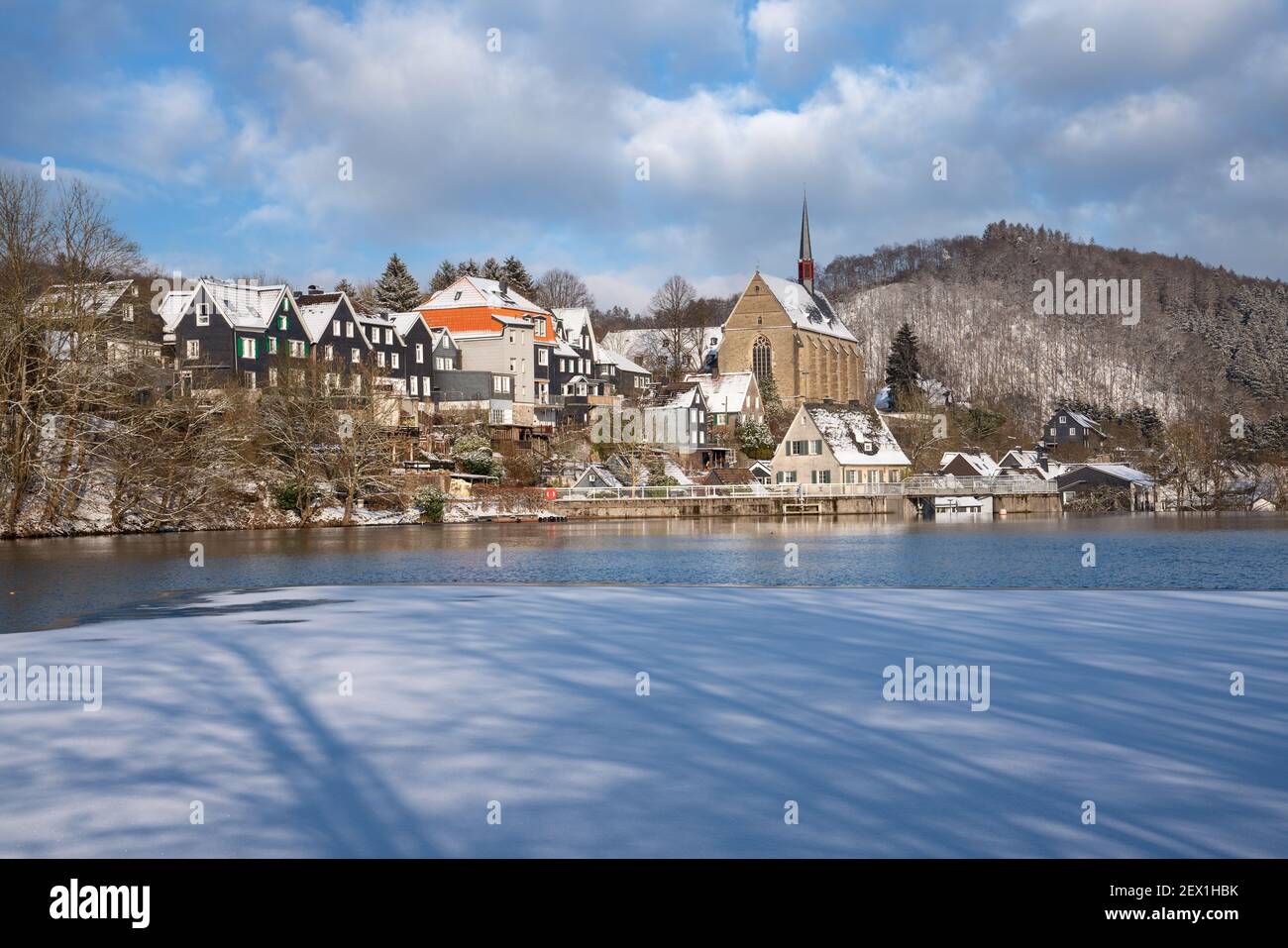 Un paesaggio di un lago circondato da alberi e neve a Beyenburg, Wuppertal, Germania Foto Stock