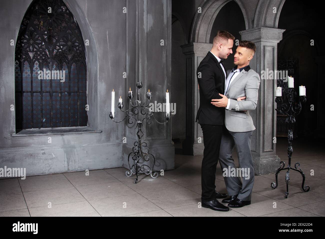 Giovane coppia gay felice sposarsi in chiesa. Amore e romanticismo. Bei uomini in abiti. Foto Stock