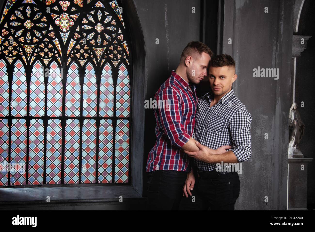 Giovane coppia gay felice sposarsi in chiesa. Amore e romanticismo. Bei uomini in abiti. Foto Stock