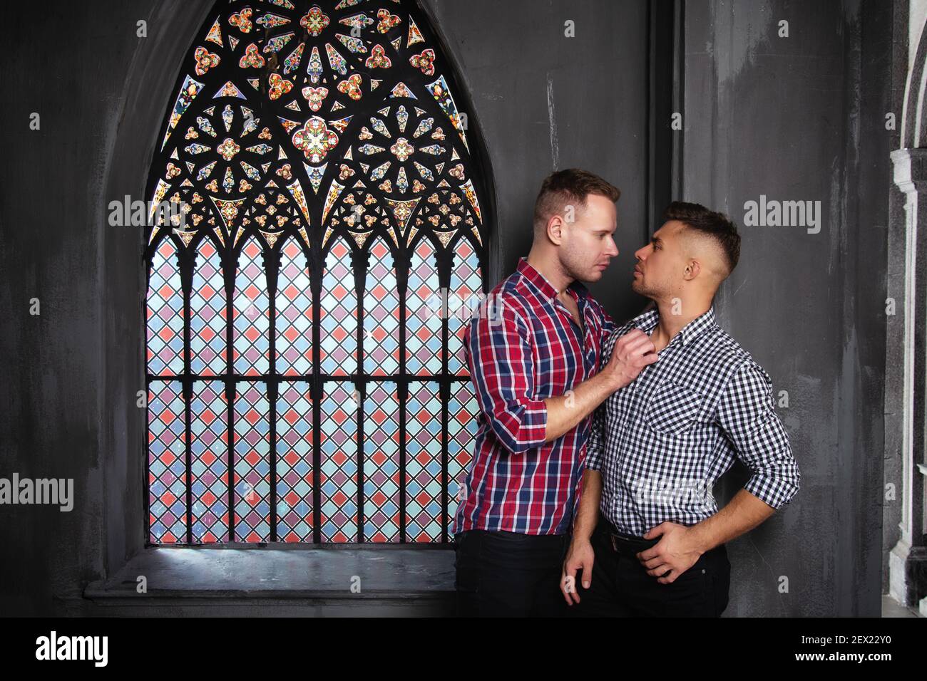 Giovane coppia gay felice sposarsi in chiesa. Amore e romanticismo. Bei uomini in abiti. Foto Stock