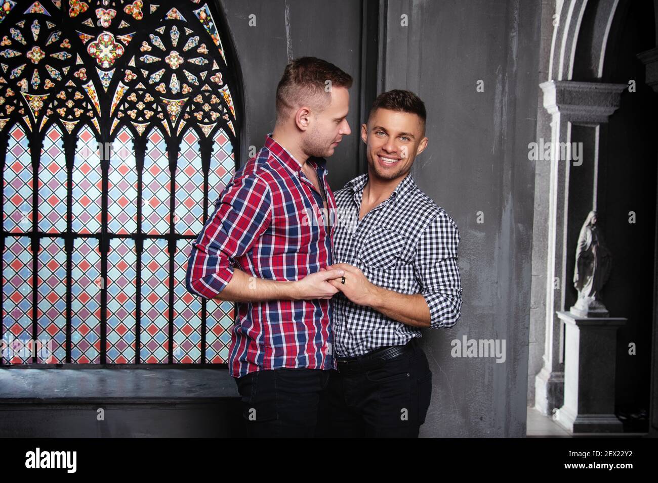 Giovane coppia gay felice sposarsi in chiesa. Amore e romanticismo. Bei uomini in abiti. Foto Stock