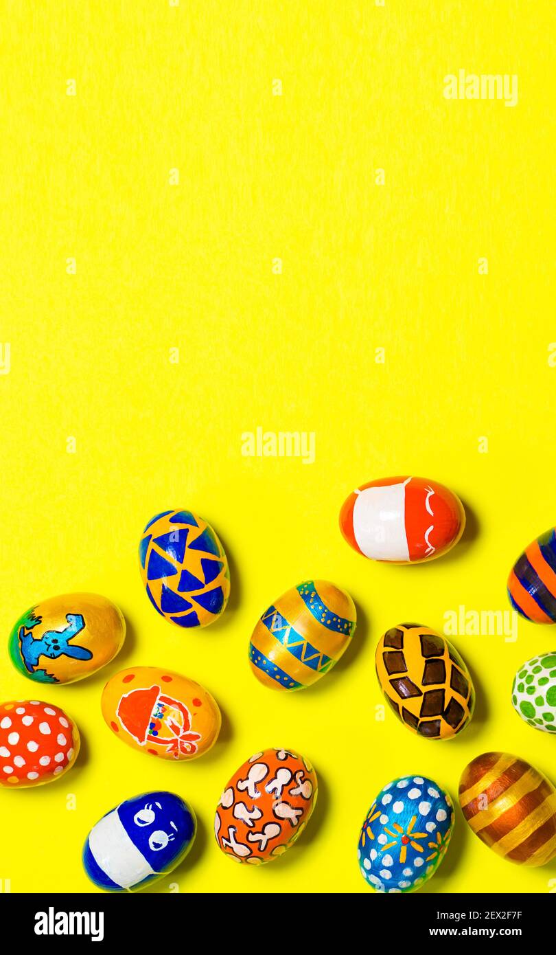 Cartolina fotografica verticale con spazio per la copia del testo su sfondo giallo con uova dipinte festive Foto Stock