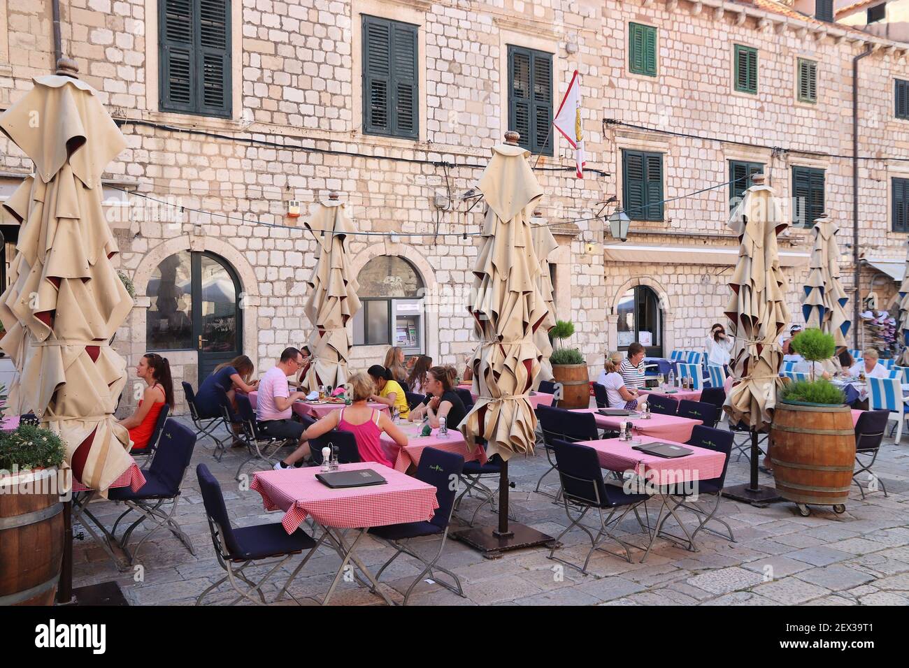 DUBROVNIK, CROAZIA - 26 LUGLIO 2019: I turisti cenano fuori nella città vecchia di Dubrovnik, un sito patrimonio dell'umanità dell'UNESCO. Foto Stock