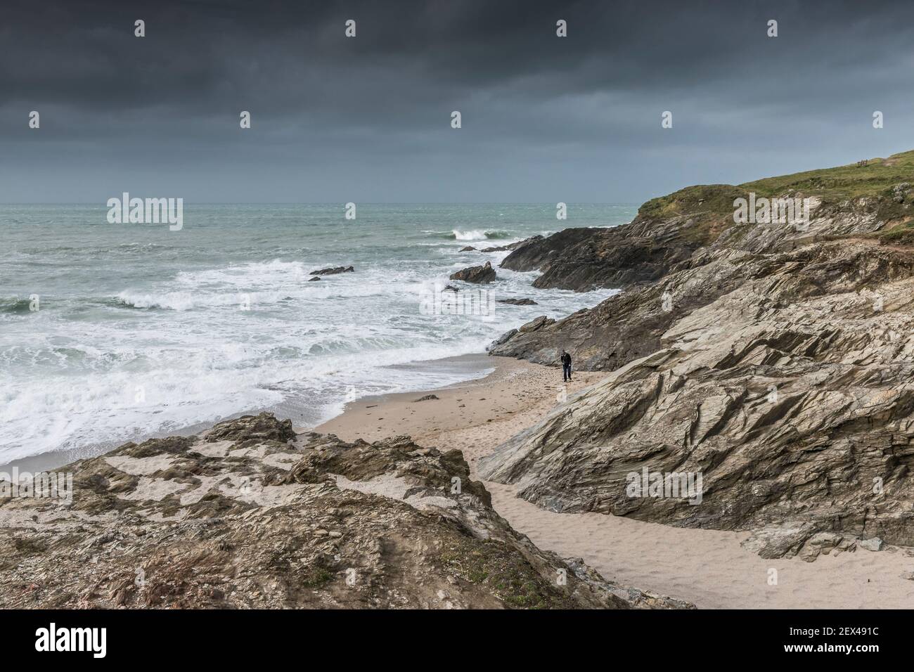 Una persona sola che cammina sulla spiaggia in una baia appartata a Little Fistral a Newquay in Cornovaglia. Foto Stock