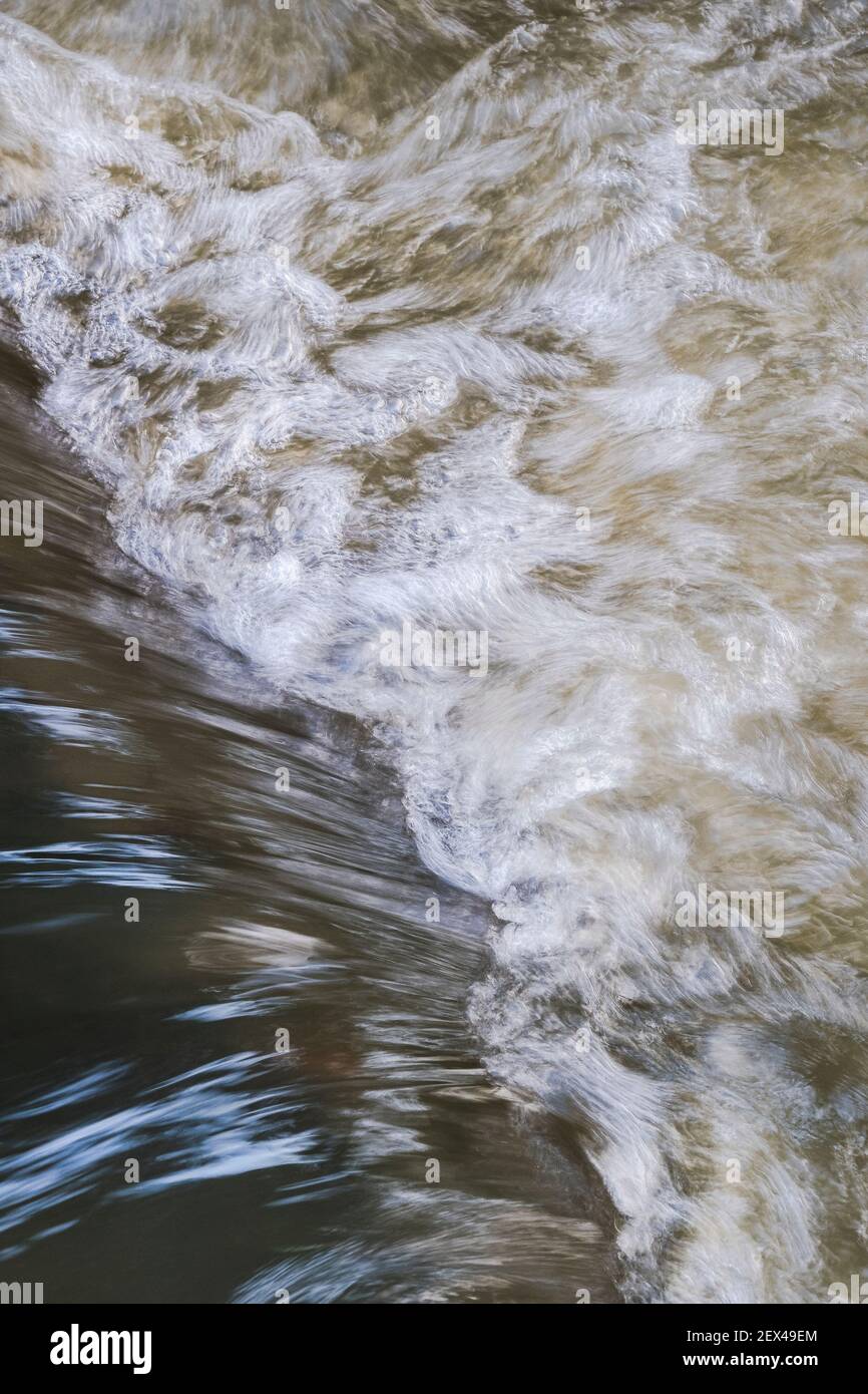 Acqua che vortola in fondo ad una piccola cascata in un ruscello. Foto Stock