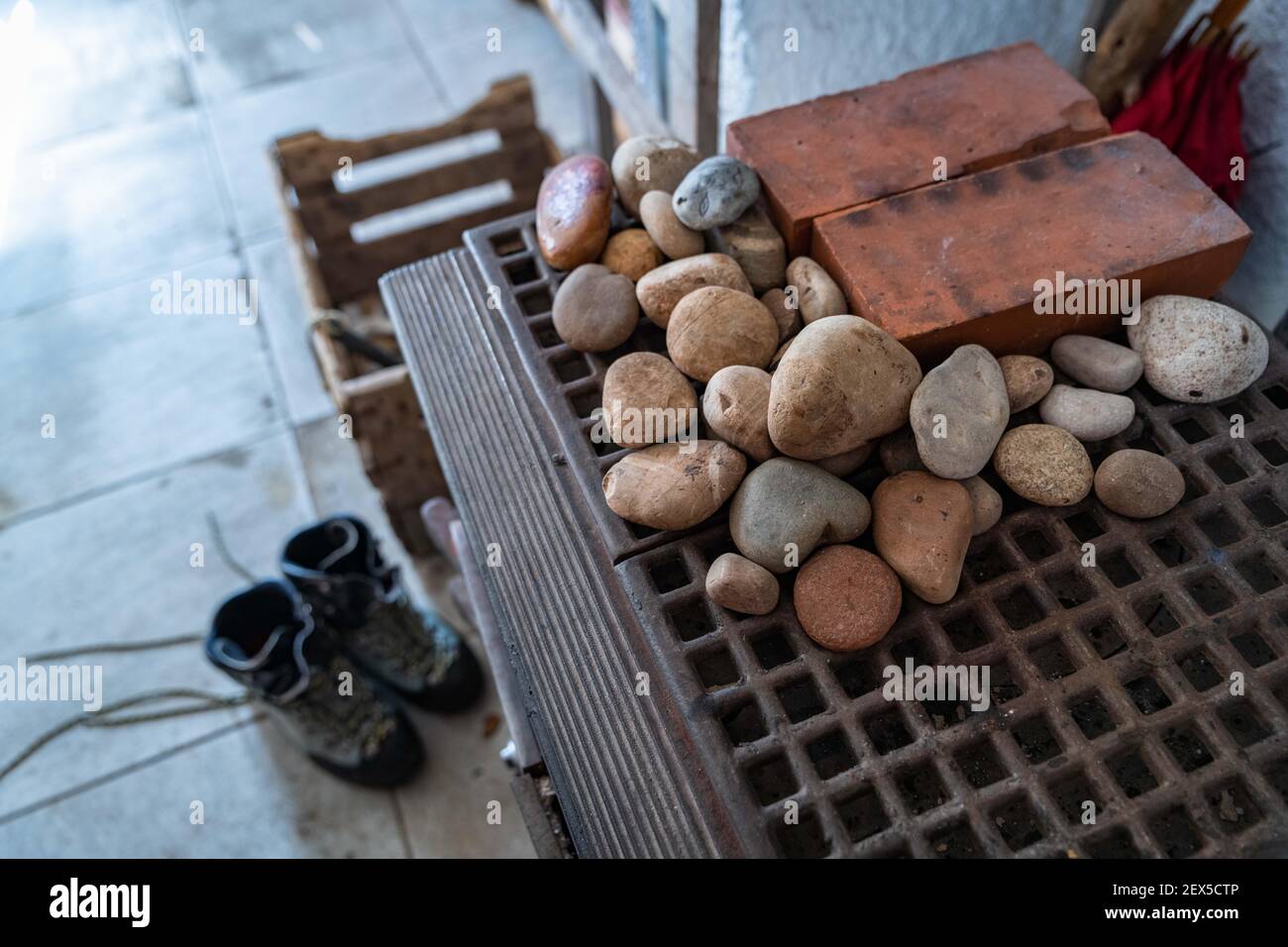 stufa a legna e stivali di montagna in un rifugio Foto Stock