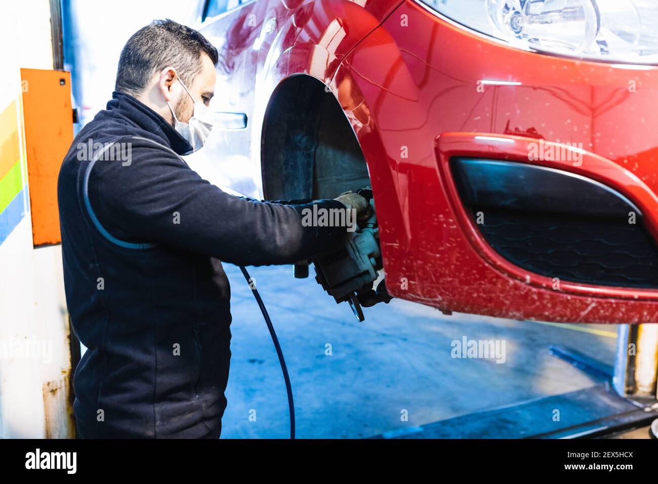 Meccanico che sostituisce le pastiglie dei freni sulla vettura. Concetto di riparazione auto. Foto Stock