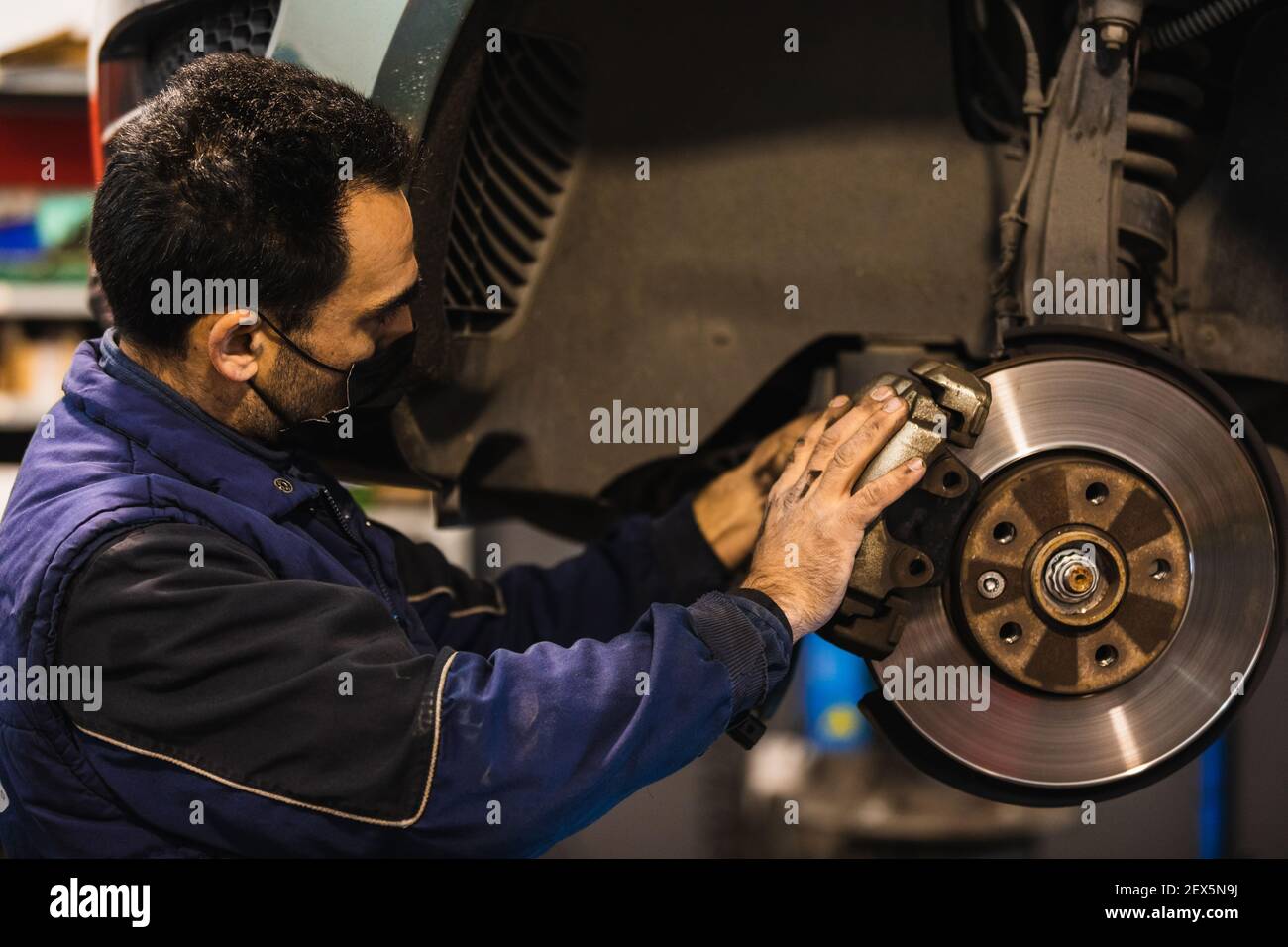 Meccanico che ripara le pastiglie dei freni della vettura. Concetto di riparazione del veicolo Foto Stock