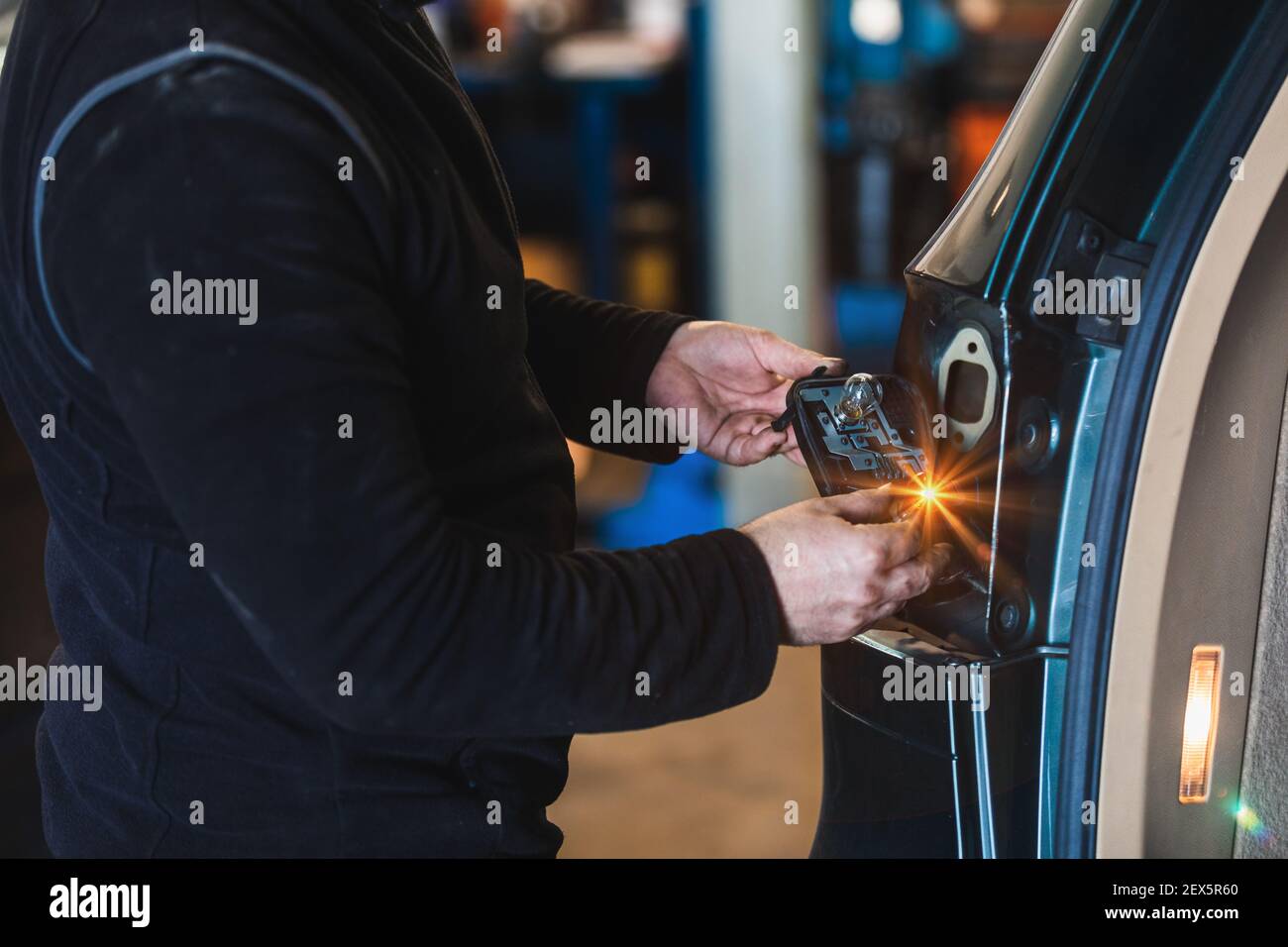 Meccanico che ripara la luce posteriore dell'auto. Officina elettromeccanica. Lavorare con le mani. Strumenti. Concetto di riparazione auto Foto Stock