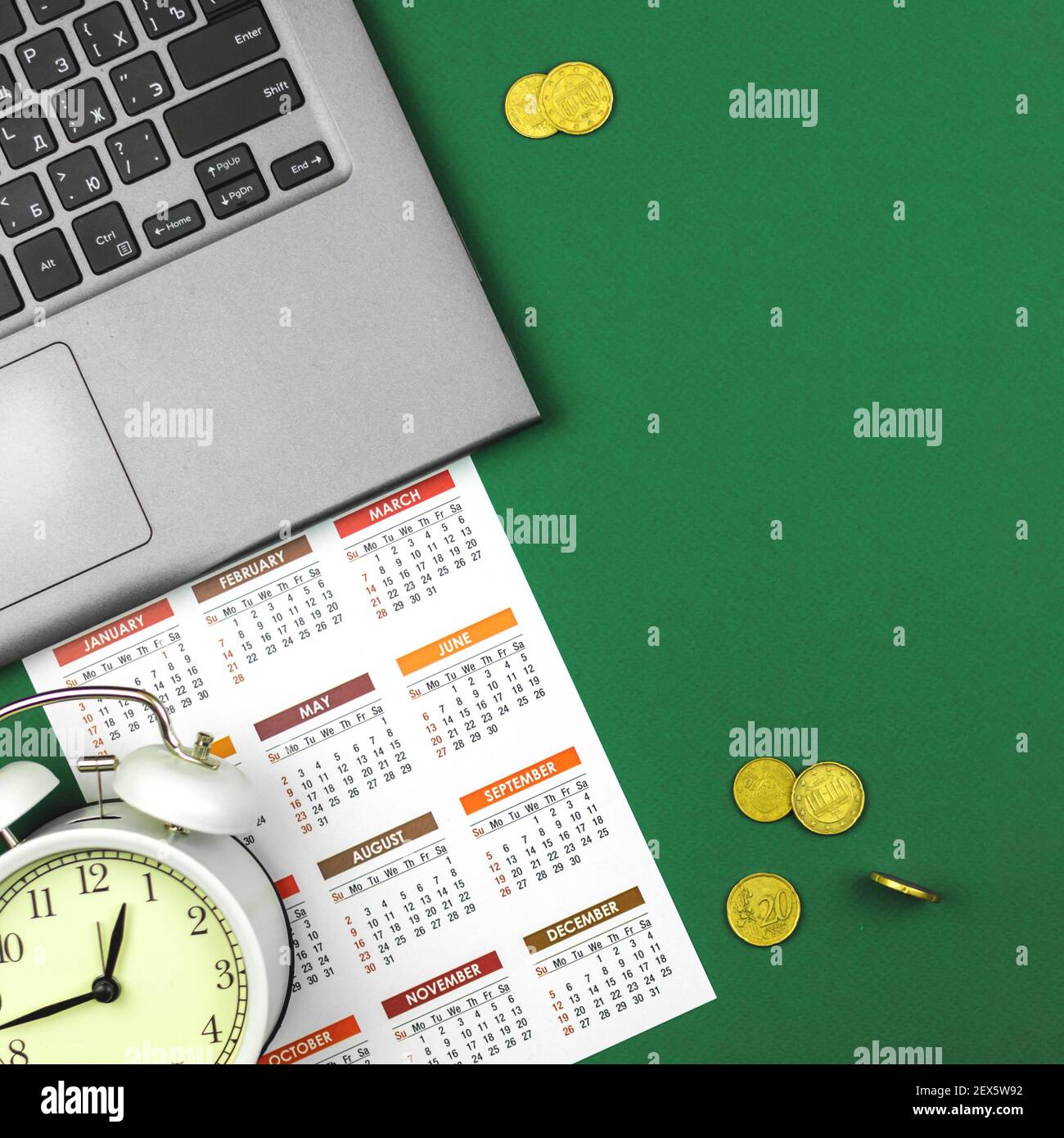 Scrivania da ufficio business con computer portatile e calendario con soldi, monete d'oro, il tempo è denaro concetto foto Foto Stock