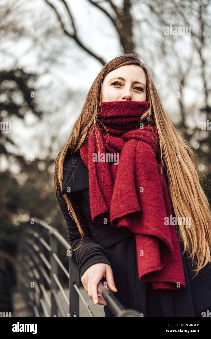 Ritratto esterno di una donna alla moda in posa invernale in un parco cittadino panoramico Foto Stock