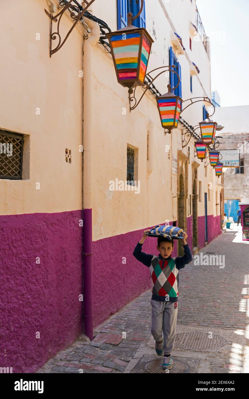Marocco, Essaouira, ragazzo che si prende cura del pane su un vassoio sulla testa Foto Stock