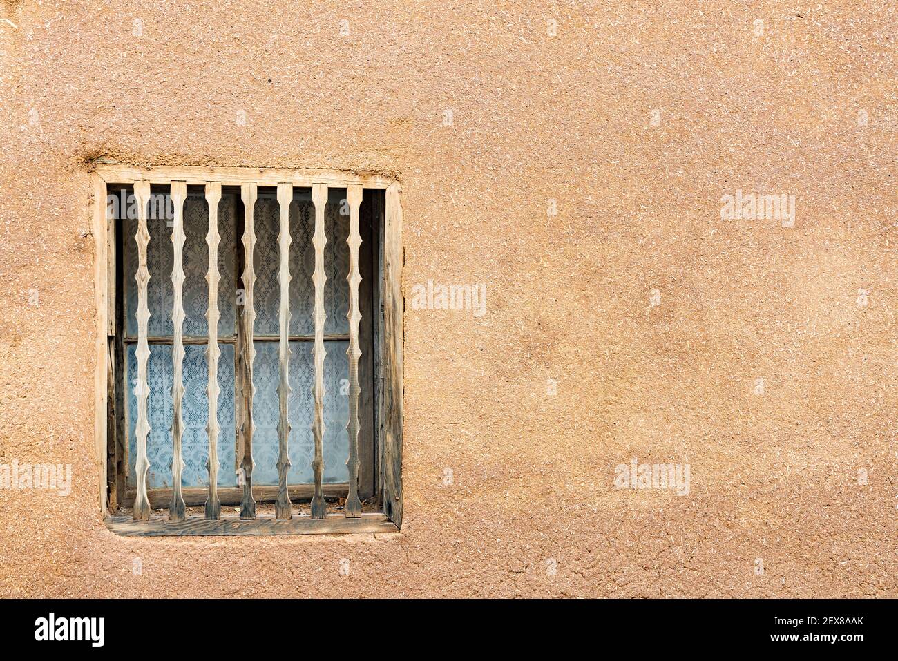 Old Southwestern Brown Adobe muro e finestra con decorativo legno mandrini Foto Stock