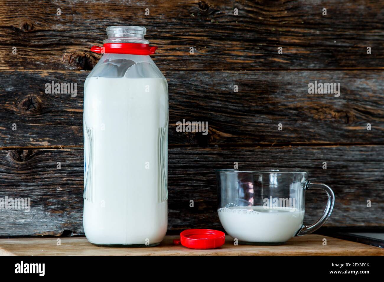 Bottiglia con latte biologico in cucina con legno rustico sfondo Foto Stock