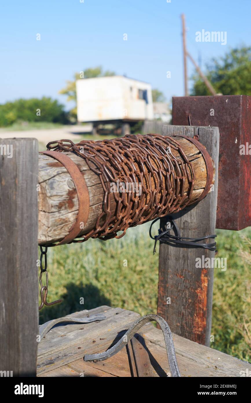 Moderno rustico legno estrazione acqua bene Rusty catena Foto Stock