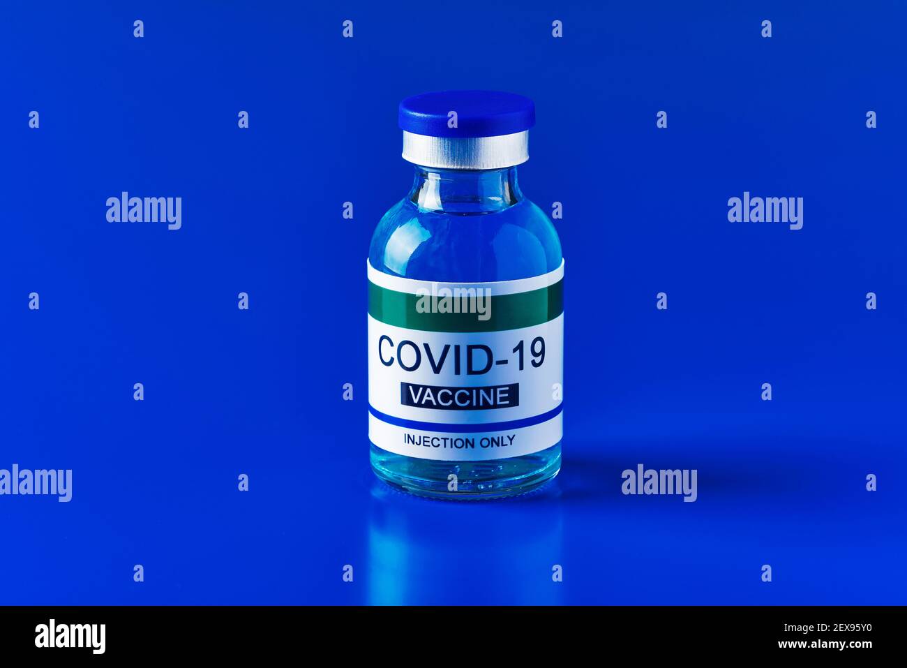 una bottiglia vaccinale simulata di covid-19 su sfondo blu, con un po' di spazio vuoto intorno ad essa Foto Stock