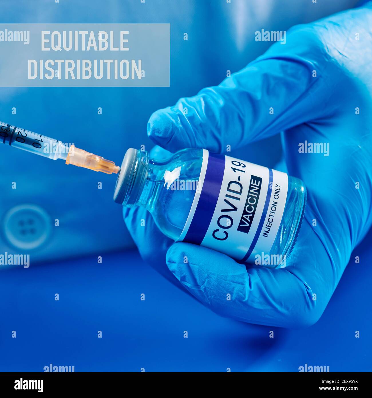 chiusura di una persona, indossando camice bianco e guanti chirurgici blu, riempire una siringa da un flaconcino simulato di vaccino covid-19, e il testo equitable Foto Stock
