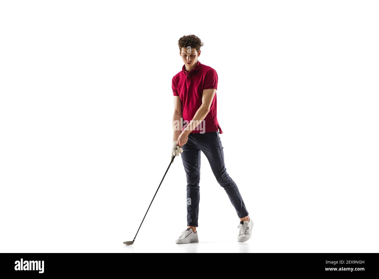 Obiettivo. Giocatore di golf in una camicia rossa isolata su sfondo bianco studio con copyspace. Giocatore professionista che pratica con emozioni ed espressione facciale. Sport, movimento, concetto di azione. Foto Stock