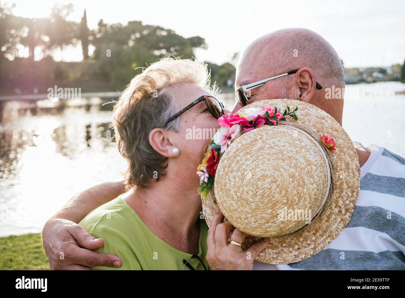 coppia di 60 anni che baciano in un parco Foto Stock