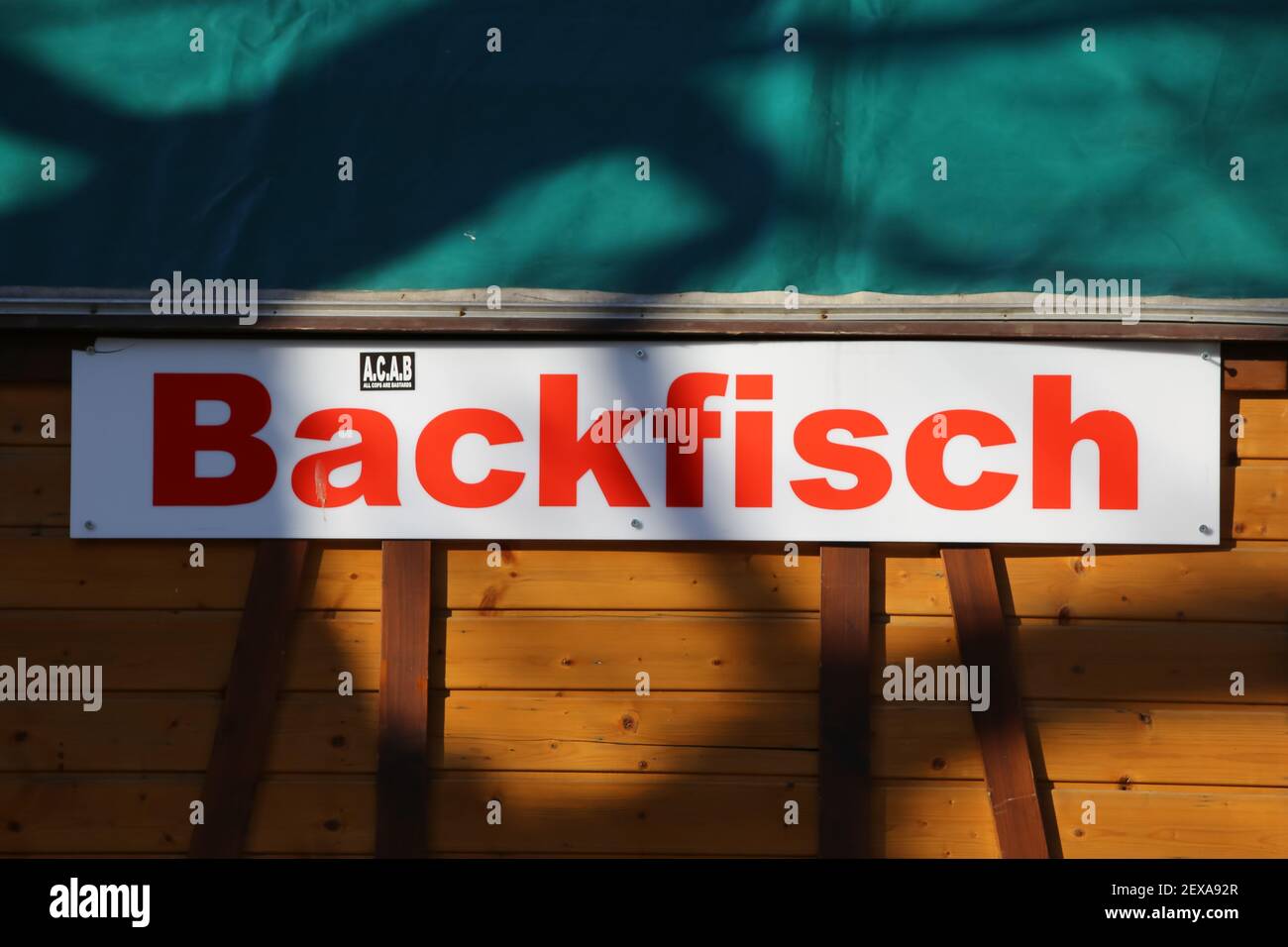 Düsseldorf, Germania - 1 marzo. 2021: Vista su segno isolato con testo rosso Backfisch (pesce fritto) a parete di bancarella di legno mercato (fuoco sulla parte destra di Foto Stock