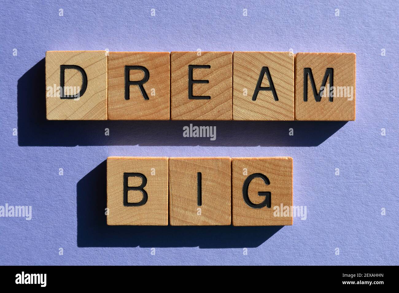 Dream Big, parole in lettere alfabetiche in legno isolate su sfondo viola Foto Stock