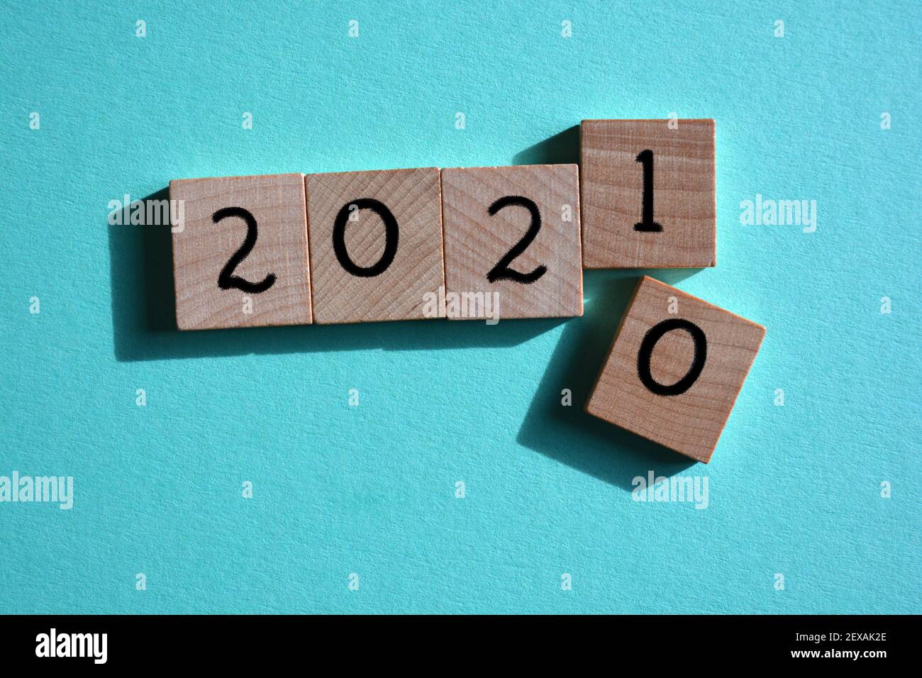 2021 anno nuovo dopo il 2020, numeri di blocchi di legno isolati su sfondo blu Foto Stock