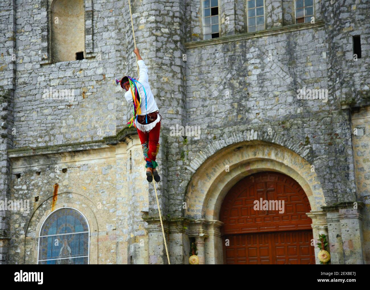 Ballerino che esegue il rituale Danza dei volantini intorno ai 30 metri di fronte palo della Parroquia de San Francisco de Asís a Cuetzalan, Messico. Foto Stock