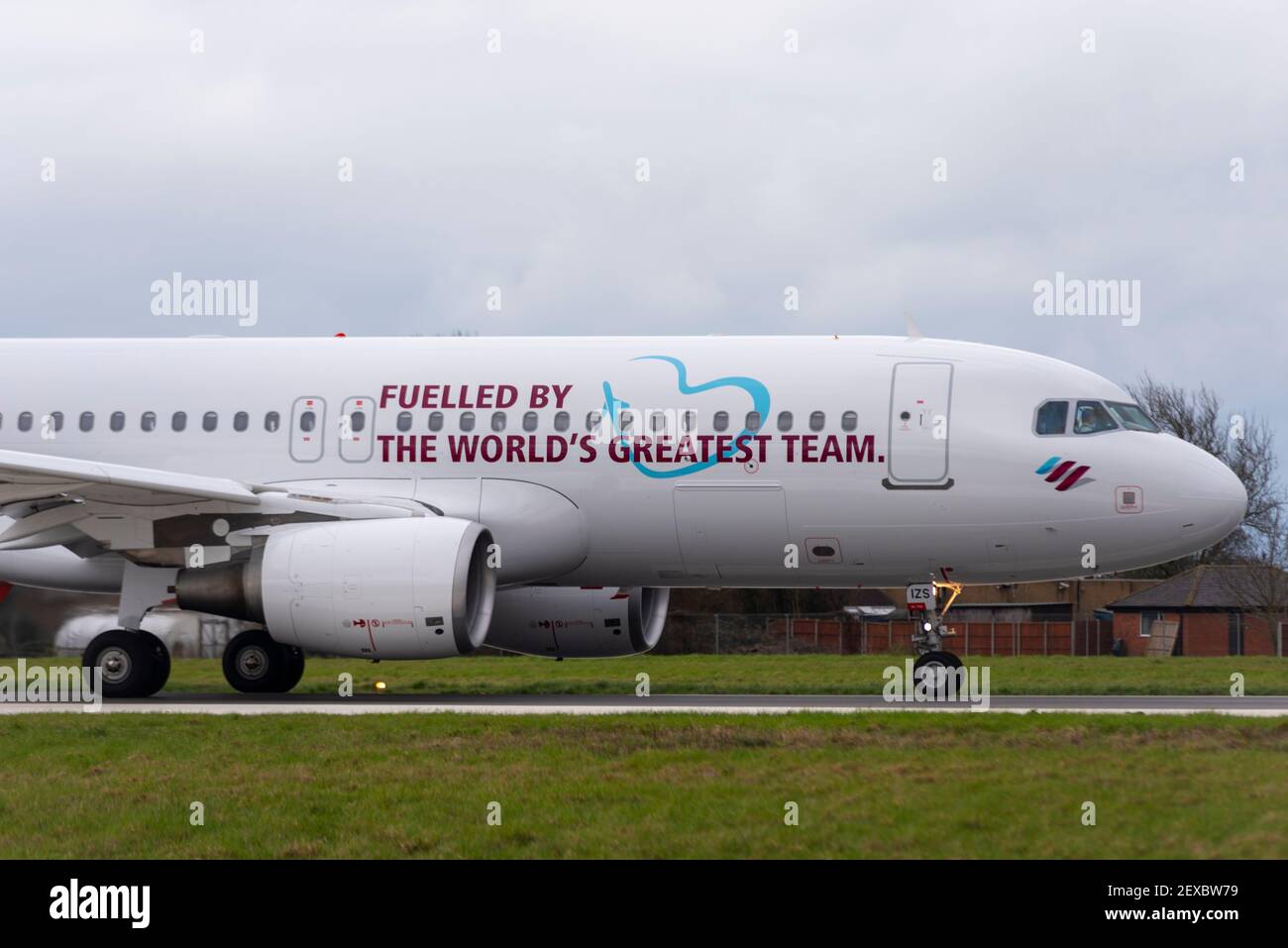 Aeroporto Southend di Londra, Essex, Regno Unito. 4 Marzo 2021. La compagnia aerea tedesca Eurowings ha aggiunto un messaggio a uno dei loro aerei per ringraziare i loro dipendenti per gli sforzi compiuti durante la pandemia di COVID 19. Da una parte ‘alimentata dalla più grande squadra del mondo’ in inglese, e in tedesco dall’altra. L'Airbus A320 è stato volato a Satys Air Livery a Southend per il lavoro e oggi è partito per entrare in servizio. Jens Bischof, CEO di Eurowings: "I nostri dipendenti hanno dimostrato uno spirito di squadra eccezionale durante la crisi. Per questo vogliamo ringraziarvi in modo straordinario». Foto Stock