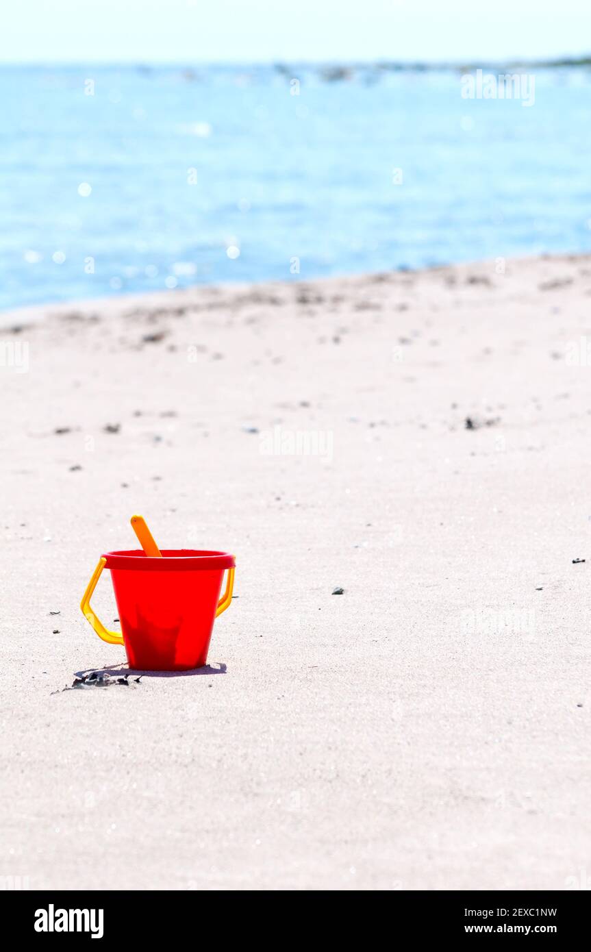 Secchio giocattolo rosso sulla spiaggia Foto Stock